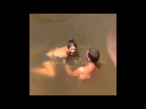 فتاة تمسك سمكة بيدها من بحيرة