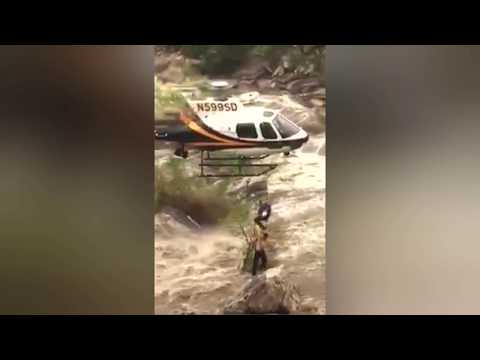 شاهد لحظة إنقاذ شاب علق وسط مياه الفيضانات بطائرة هليكوبتر