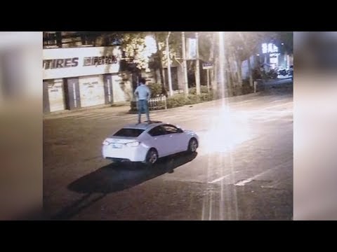 a man takes a ride on car’s roof after getting drunk
