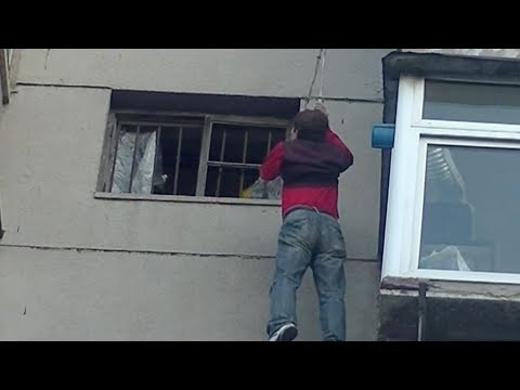 firefighters rescue man dangling from top of building