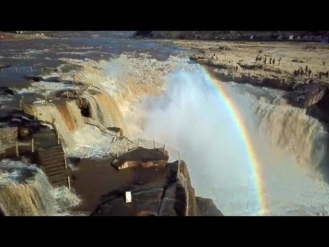 rainbow over northern china waterfall attracts