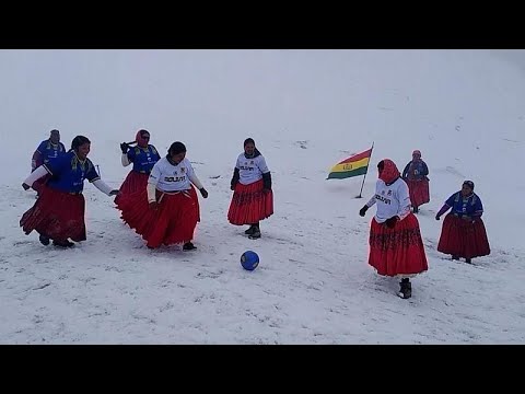سيدات من بوليفيا يلعبن كرة القدم فوق الثلج بتنانيرهن التقليدية